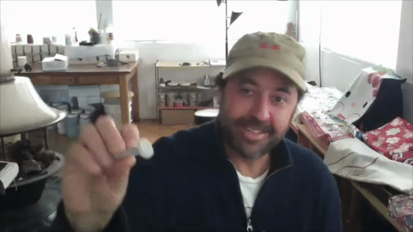 A person holds up a tool made to create a fingerprint imprint.